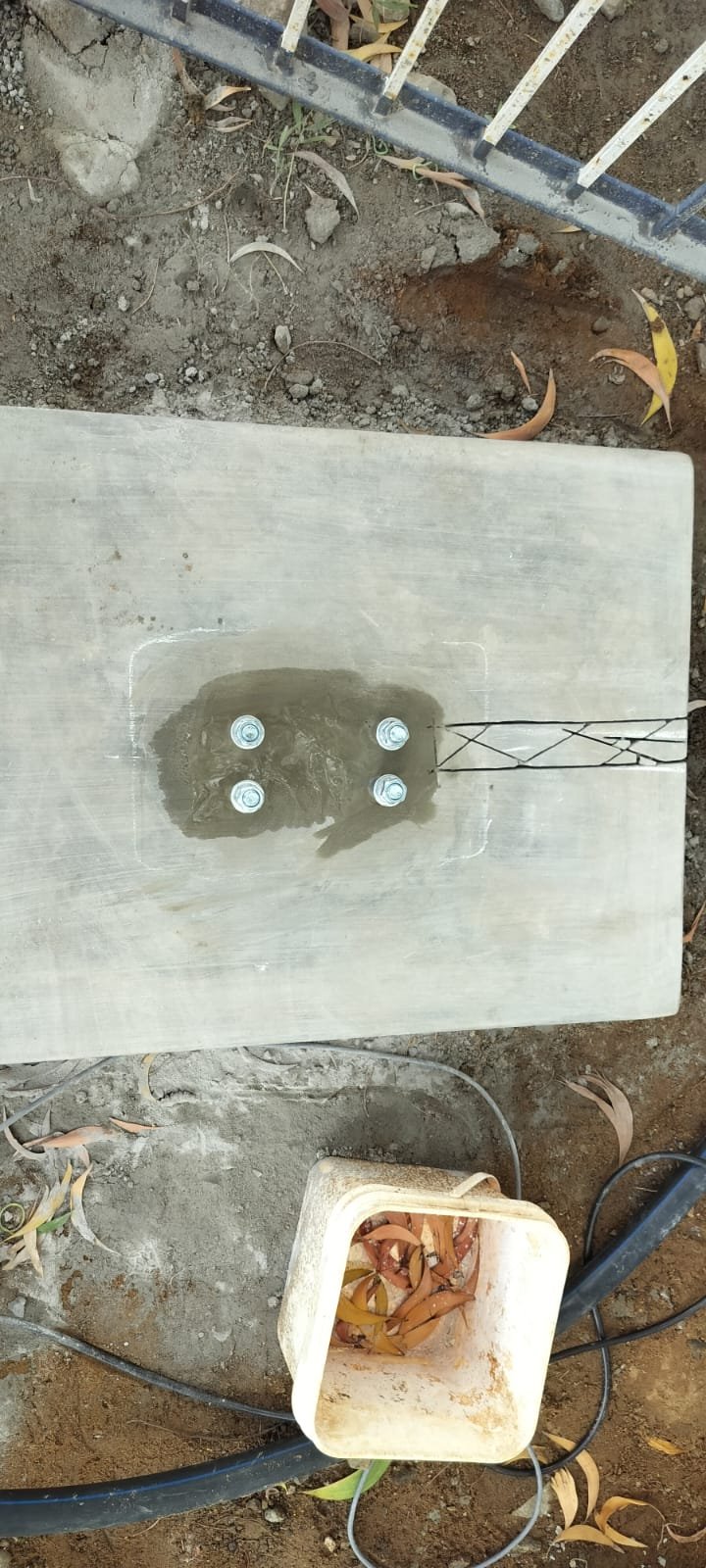 Concrete boom-barrier base with four anchor bolts at Royal Hatcheries